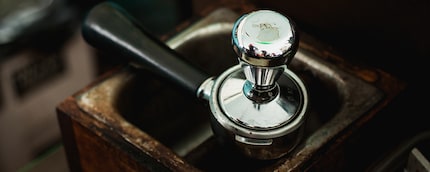 A tamper is used to compress the espresso powder.