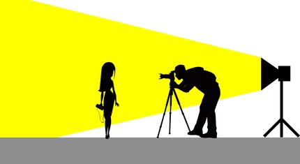 The light source is behind the photographer and shines on the model