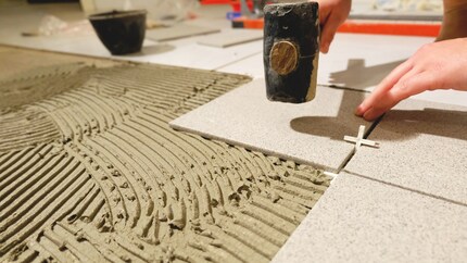 Punta con decisione per assicurarti che le piastrelle rimangano al loro posto. E non dimenticare gli incroci tra le piastrelle.