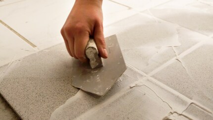 Muovi in diagonale le piastrelle in modo da riempire le fughe in modo uniforme.