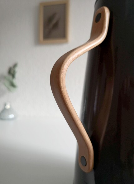 Cette anse en bois ressemble à s'y méprendre à la poignée d'une sacoche.