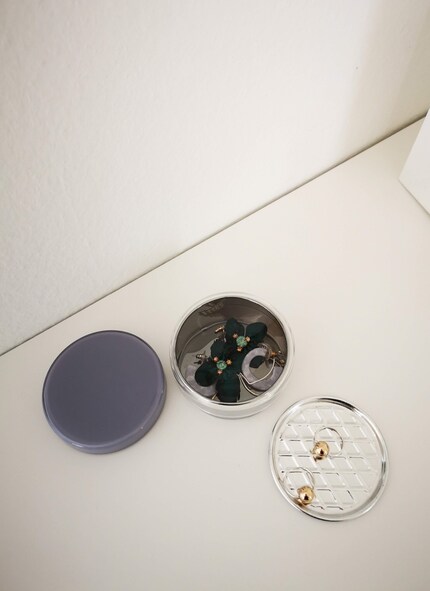 Je place les boucles d'oreille sur des dessous de verre et dans des petites boîtes translucides. De cette manière, je retrouve plus vite ce que je cherche.