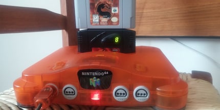 Das schwarze Modul in der Mitte mit der 8 ist der sogenannte Gameshark, ein Cheatmodul für den Nintendo 64. Quelle: Gameshark