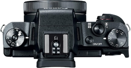 Beispiel Canon G1X Mark III: Zu sehen sind hier das Moduswählrad (links), ein eigenes Drehrad für die Belichtungskorrektur (ganz rechts) und ein allgemeines Drehrad (vorne rechts). Dazu kommen diverse weitere Tasten auf der Rückseite neben dem Bildschirm.