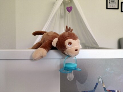 On dirait que le singe a la sucette dans la bouche, car le velcro est fixé en dessous.