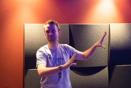 Martin erklärt sein Kino. Im Hintergrund: Die roten Gipskartonwände und die Absorber.
