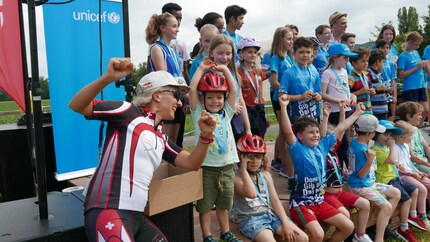Triathletin Natascha Badmann verteilt Goldmedaillen an die teilnehmenden Kinder.