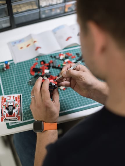 Thomas applica gli adesivi come un professionista, armandosi di pinzette.