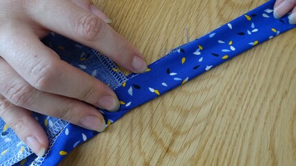 Piega il nastro a filo per tutta la sua lunghezza. Cucendo il lato aperto con la macchina, fisserai contemporaneamente il nastro alla cintura e prenderai due piccioni con una fava.