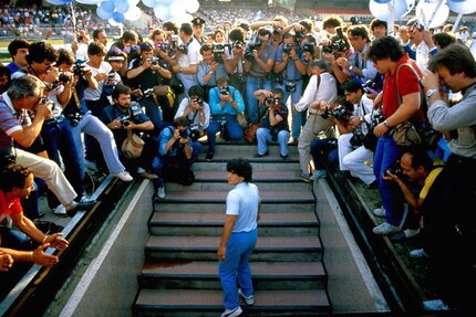 Dal basso verso l'alto: Diego arriva a Napoli nel 1984 e viene accolto da 85.000 tifosi allo Stadio San Paolo.