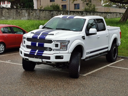 Die Heckklappe des Autos ist etwas über dem Randstein. Der Parkplatz hat Standardgrösse.