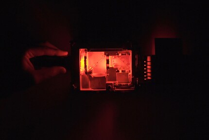 In contrast to blue, red passes through both mirrors to the lens.