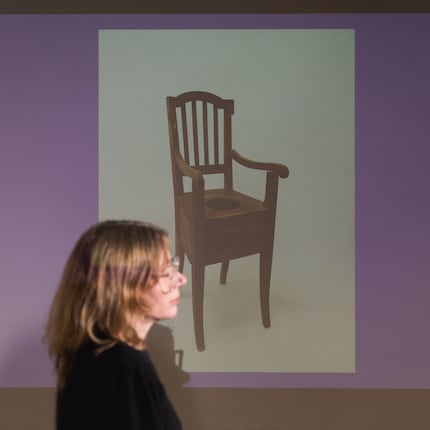 A commode chair assists bedridden and physically handicapped people. It's usually mobile and can be used right next to the bed.