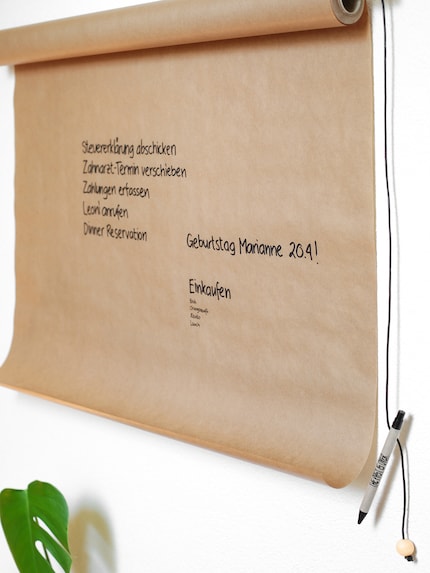 Am besten hängst du auch einen Stift mit einem Lederband an den Wand-Notizzettel.