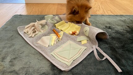 Für stürmische Hunde lässt sich die Matte mit den beiden Bändern an einem stabilen Gegenstand wie einem Tischbein befestigen.