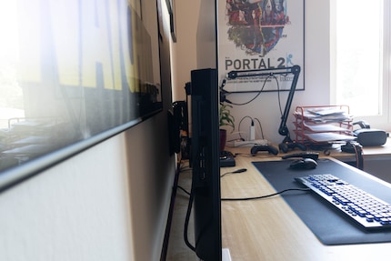 Eine Wandhalterung sorgt für Abstand und mehr Platz auf dem Pult.
