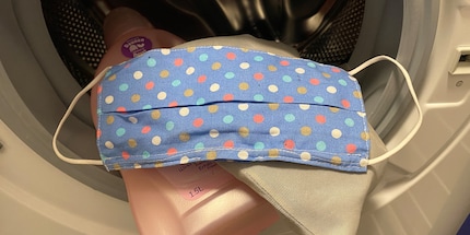 A touch of liquid laundry detergent and a laundry net will get your mask spiffy clean.