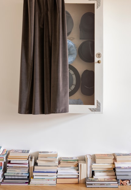 Impilati con il taglio di piede visibile e il dorso nascosto, i libri sono più discreti e si fondono con la parete bianca. Immagine: Ferm Living