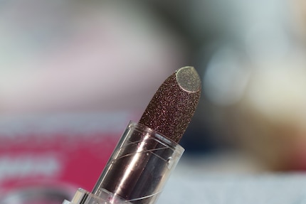 Der Lippenstift ist mit einem feinen Netz aus Glitter überzogen.