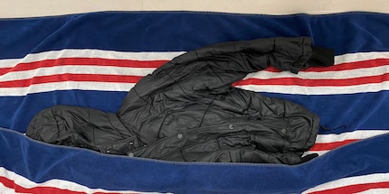 Ins Tuch einrollen und das Wasser auspressen: So trocknet die Daunenjacke schneller.