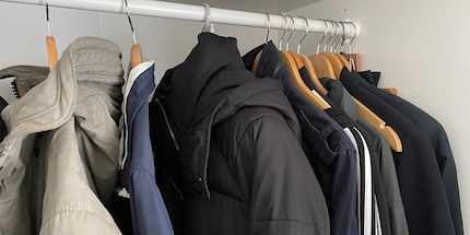 Im Kleiderschrank und an einem Bügel aufgehängt, wartet deine Daunenjacke auf ihren nächsten Einsatz.