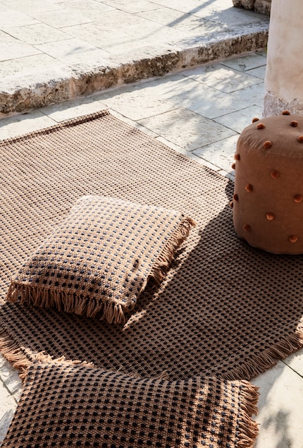 Un tapis d'extérieur et des coussins apporteront la touche confort à votre extérieur. Photo : Ferm Living