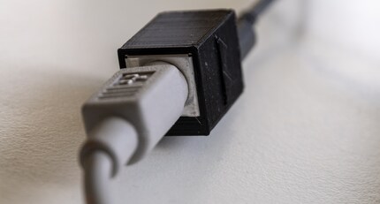 The tiny adapter has an ADB input and a microUSB output.