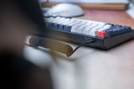 Le bouton pour passer de Mac à Windows et le port USB-C se trouvent à l'arrière gauche.