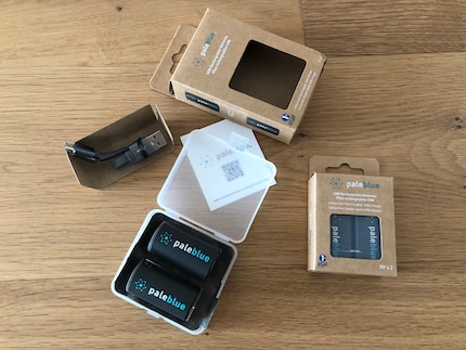 Le boîtier en plastique dur contenant les piles et le câble de recharge sont emballés dans un carton.