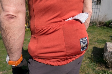 Espace de rangement pour la veste coupe-vent. Les écouteurs dans la poche latérale gauche.