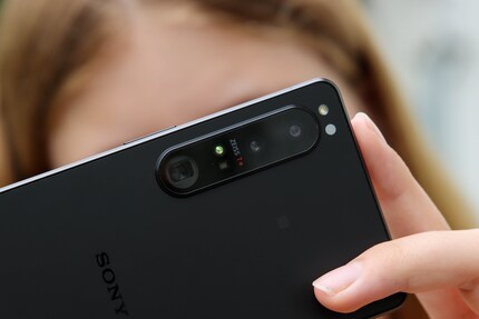 Trois petits objectifs du smartphone à la place de l'appareil photo reflex avec un grand objectif.