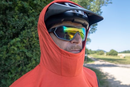 The large-cut hood fits over the helmet.