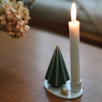 Piccolo, ma di grande effetto: l'albero di Natale in ceramica risplende alla luce della candela