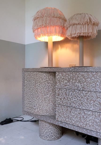 The curved doors of this monumental piece of furniture conceal a space for bottles and glasses.