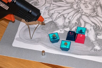 Con i keycap, la colla a caldo e piccoli magneti, si ottengono rapidamente dei magneti da frigo fatti in casa.
