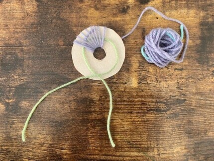 Inserisci il primo filo fino in fondo per stringere il pompon alla fine.