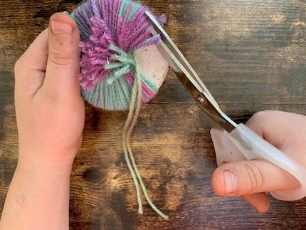 Il punto critico: taglia con attenzione lungo il bordo esterno in modo che i fili non scivolino via prima di stringerli.