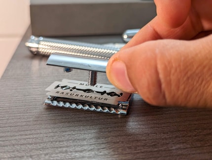 The thin steel blade is clamped into the shaving head.