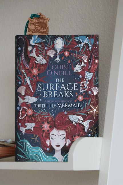 «The Surface Breaks» wurde erstmals 2018 veröffentlicht. Das wunderschöne Cover stammt von Illustratorin Paola Escobar.