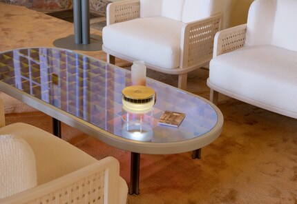 Er besteht aus einem Gittergestell und einer irisierenden Tischfläche aus Glas.