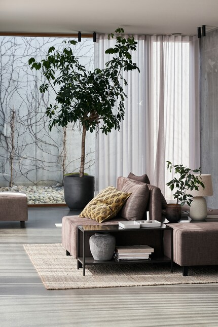 Instead of being stuck to the wall, the storage unit is integrated into the sofa group.