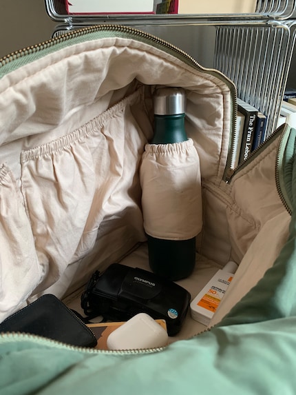 À l’intérieur, il y a trois poches latérales de tailles différentes et un porte-bouteille.
