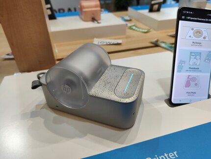 The printer is available in speckled grey or pink.