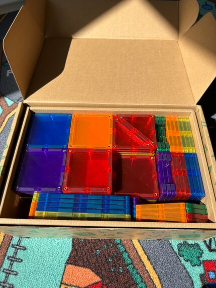 The box includes brightly coloured building tiles in a variety of sizes.