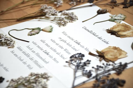Prêtes pour le cadre en verre : les fleurs pressées du bouquet de la mariée et le poème du mariage civil.