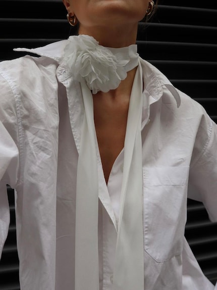 L'influenceuse Millie Holmes associe une fleur en tissu blanc à un chemisier blanc - c'est parfait.