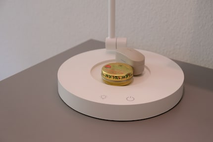 Auf dem Lampenfuss gibt es Platz für Kleinigkeiten wie ein Getränk oder Kopfhörer. Das spart Platz.