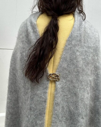 Un bel dettaglio: usa una spilla per fissare le estremità della sciarpa sul retro.