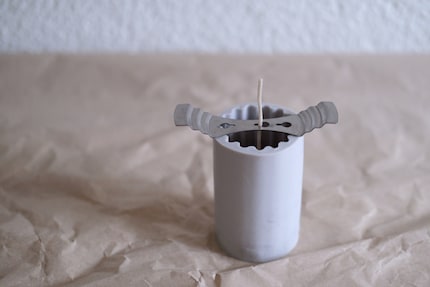 Ein Halter aus Metall hilft dabei, den Docht zu fixieren.