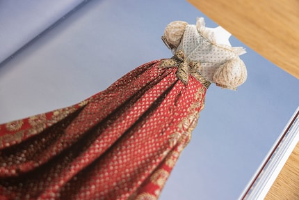 Deze hofjurk met rode zijden sleep dateert uit de jaren 1820. Illustratie uit het boek «History of Fashion from the 18th to the 20th Century».